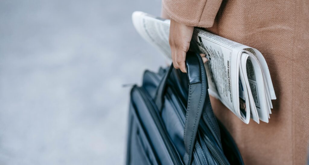 Woman carrying briefcase and newspaper