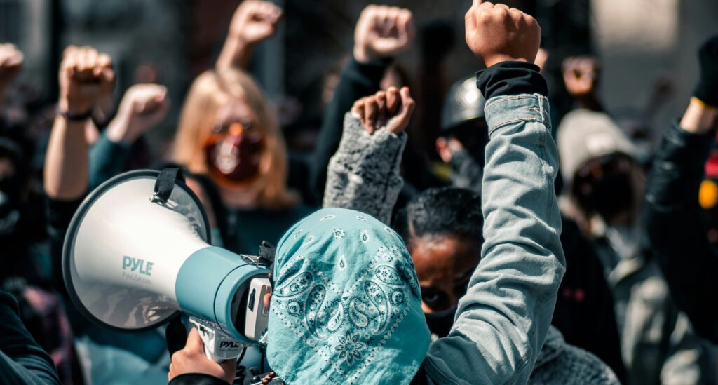 Image: protest-woman-bandana-daytime-protest-featuring-woman-with-loudspeaker